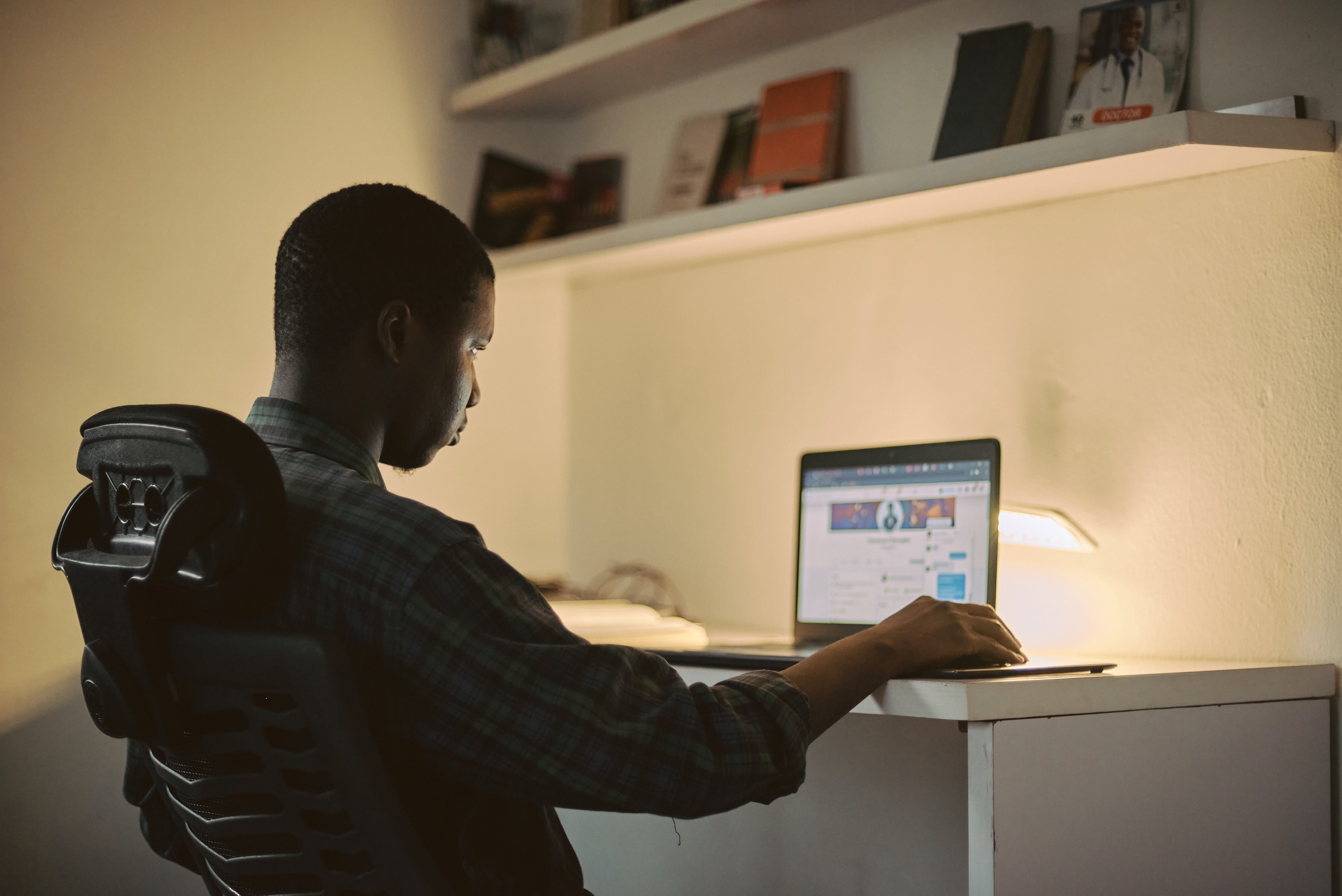 Woman sitting and looking at a lap top
      